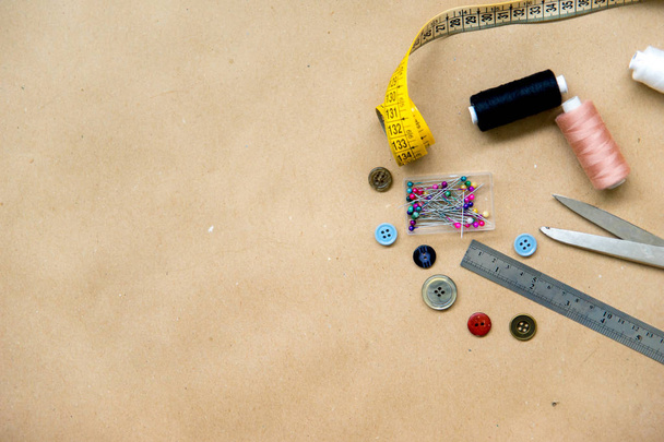 set of sewing tools - scissors, needles, buttons, thread on a table - 写真・画像