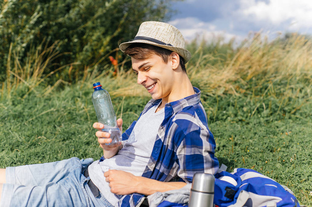 male hiker taking a break and drinking water from bottle - Foto, imagen