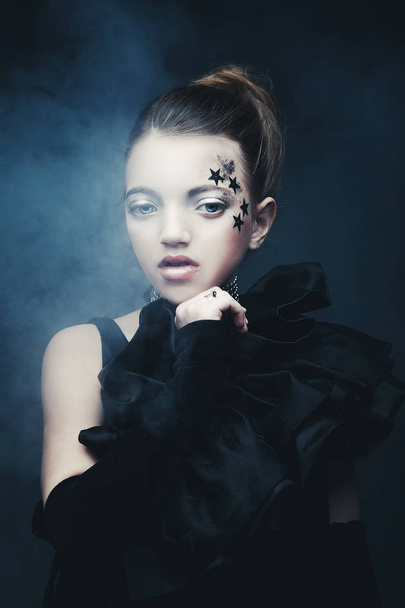 Beauty and fashion concept: Little girl wearing black outfit. Creative make up. - Valokuva, kuva