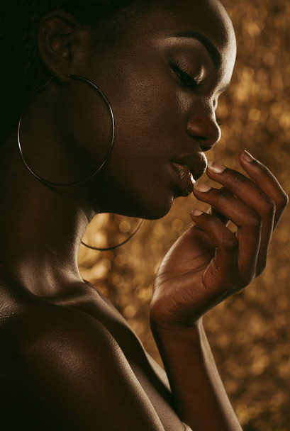 Fashion studio portrait of an extraordinary beautiful african american model with closed eyes over golden background - Φωτογραφία, εικόνα