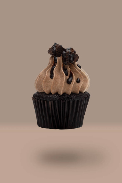 Flying cupcakes on brown background, idea minimal concept for new year, christmas holliday. - Foto, imagen