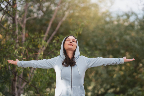 Donna in piedi allungare le braccia rilassarsi e godere con la natura aria fresca
. - Foto, immagini