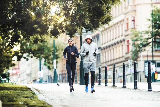 A fit couple running outdoors on the streets of Prague city. - Foto, Imagem
