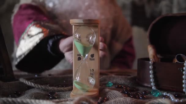 unrecognizable old man with long beard flip the sand clocks - Footage, Video