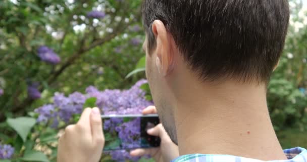 4K - Visão traseira de um cara que dispara um telefone lilás em câmera lenta
 - Filmagem, Vídeo