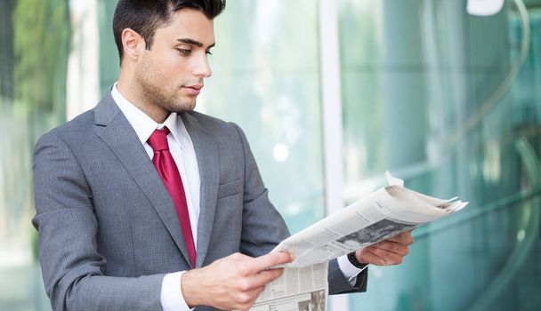 Portrait of a businessman reading a newspaper - Fotoğraf, Görsel
