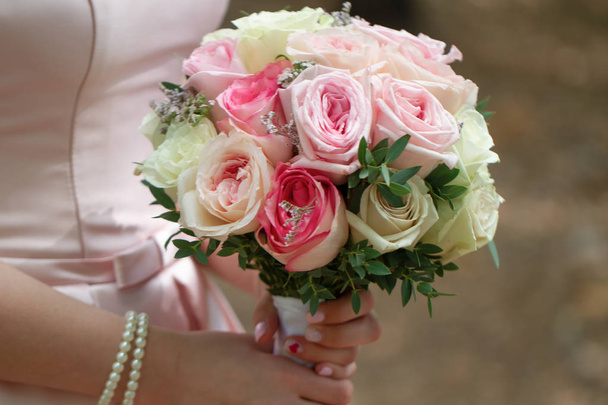 красивий весільний букет з кремових троянд в руках нареченої
. - Фото, зображення