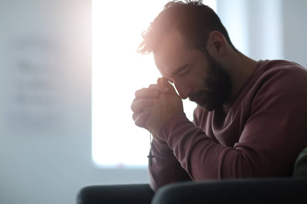 Θρησκευτικές νεαρός προσεύχεται στο Θεό στο σπίτι - Φωτογραφία, εικόνα