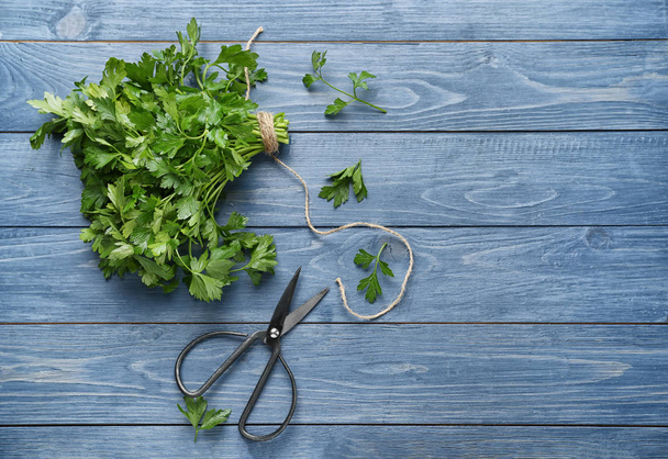 Fresh aromatic parsley with scissors on color wooden background - Valokuva, kuva