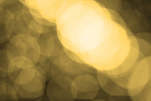 Abstract blurred gold bokeh lights background. Defocused glitter light. - Photo, Image