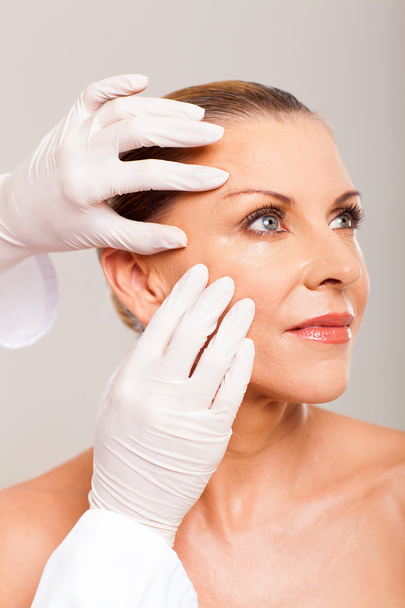 skin check on mid age woman face - Foto, Imagem