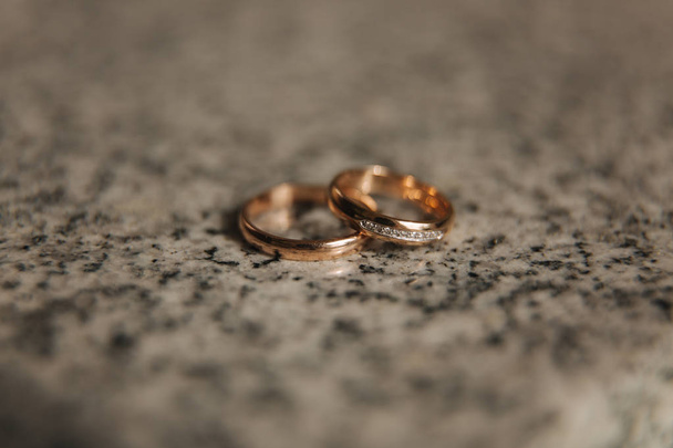 Wedding rings on table. Gold rings with diamond on sun. Wedding accsessories. macro - 写真・画像