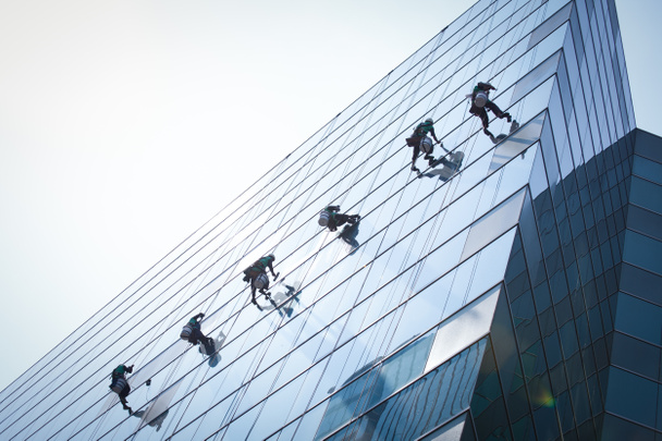grupo de trabajadores servicio de limpieza de ventanas en edificio de gran altura - Foto, Imagen