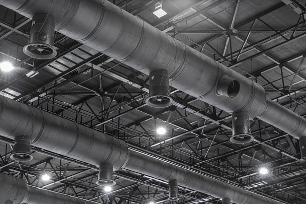 空調ダクト クリーニング、新しい建物の内側の天井からぶら下がっている銀色の断熱材で換気パイプ. - 写真・画像