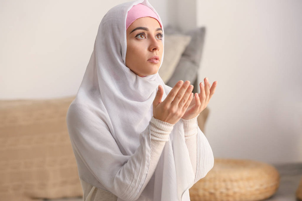 Young Muslim woman praying at home - Foto, afbeelding