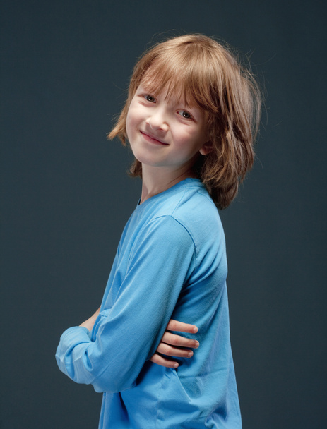 Retrato de un niño con el pelo largo y rubio en top azul
. - Foto, Imagen
