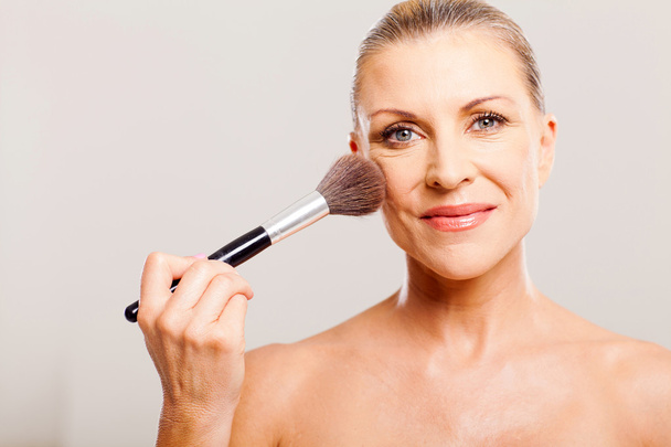 beautiful mature woman applying make up - Zdjęcie, obraz