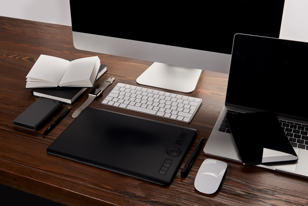 современное графическое дизайнерское рабочее место с различными устройствами на деревянном столе
 - Фото, изображение