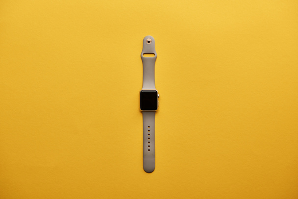 top view of smart watch with blank screen on yellow surface - Zdjęcie, obraz