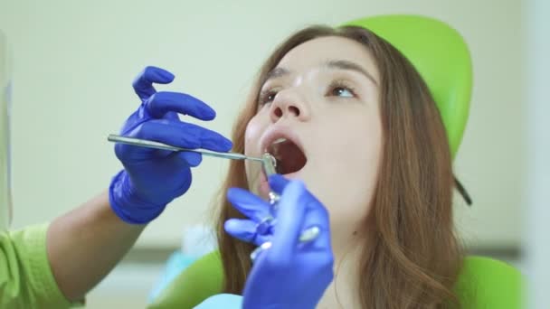 Młoda kobieta z otwartymi ustami podczas procedury stomatologiczne. Wstrzyknięcie środka znieczulającego - Materiał filmowy, wideo