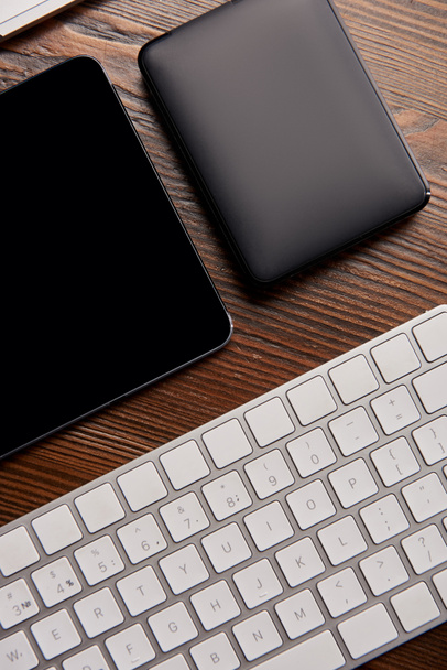 vue du dessus du clavier sans fil avec tablette numérique et hdd portable sur table en bois
 - Photo, image