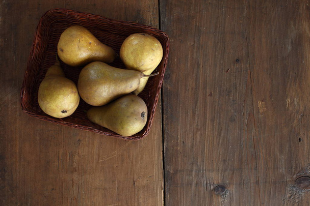 group of ripe pears lie on old planed wooden boards. - Φωτογραφία, εικόνα
