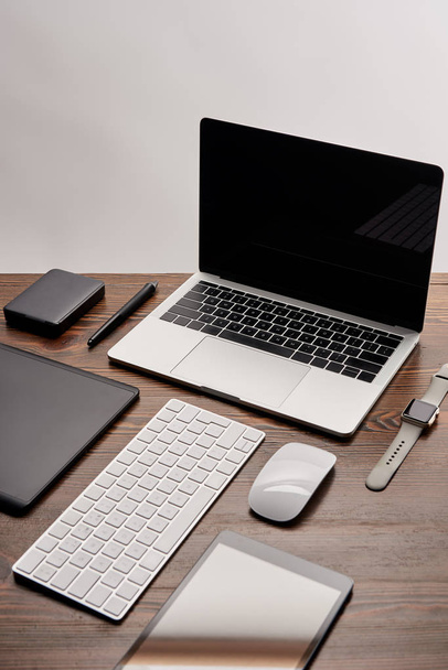 Laptop mit anderen verschiedenen Gadgets am Arbeitsplatz des Grafikdesigners - Foto, Bild