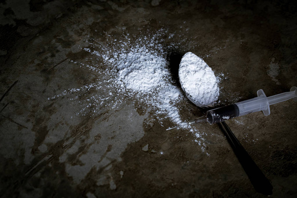 Siringa di droga e eroina cotta in cucchiaio sul pavimento
 - Foto, immagini