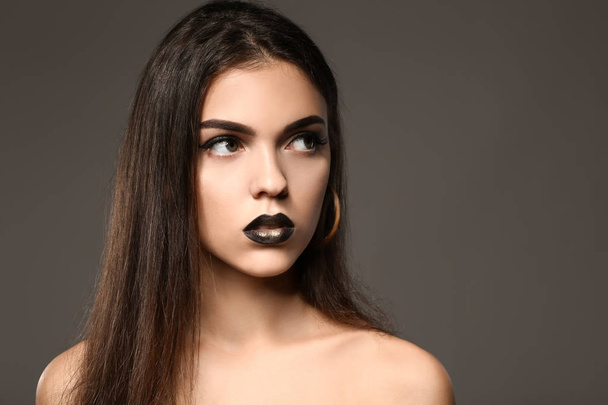 Beautiful young woman with extravagant makeup on grey background - Fotografie, Obrázek