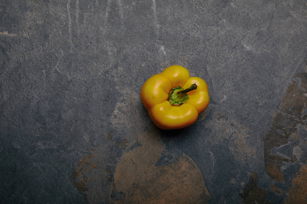 top view of yellow bell pepper on grey marble background - Фото, зображення