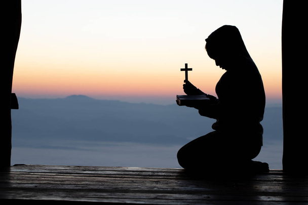 Silueta dospívající dívka ruce hospodářství dřevěný kříž na sunrise pozadí, kříž, Symbol víry. - Fotografie, Obrázek