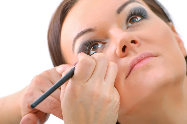 Maquiagem artista aplicando batom a um cliente em um salão de beleza
 - Foto, Imagem