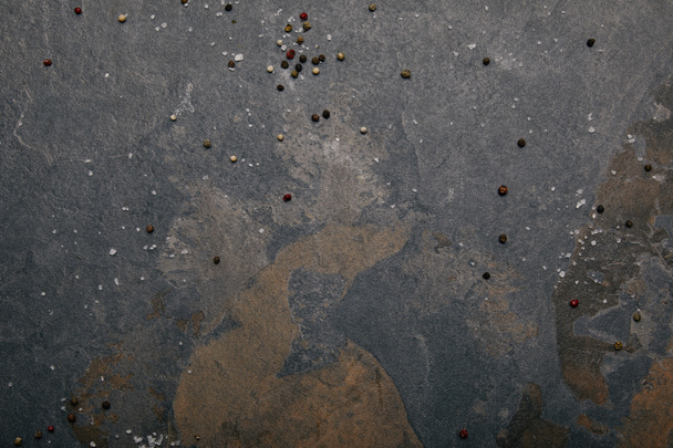top view of scattered salt and allspice on grey marble background - Foto, Bild