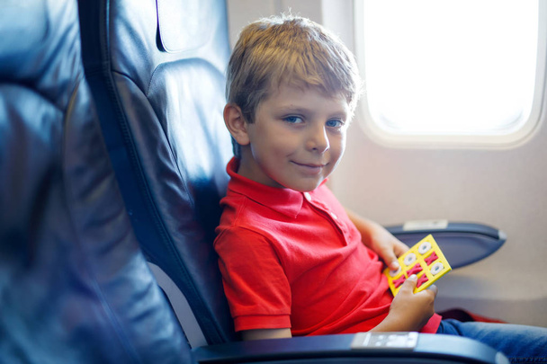Kleine jongen jongen spel tic tac teen tijdens vlucht op vliegtuig. - Foto, afbeelding