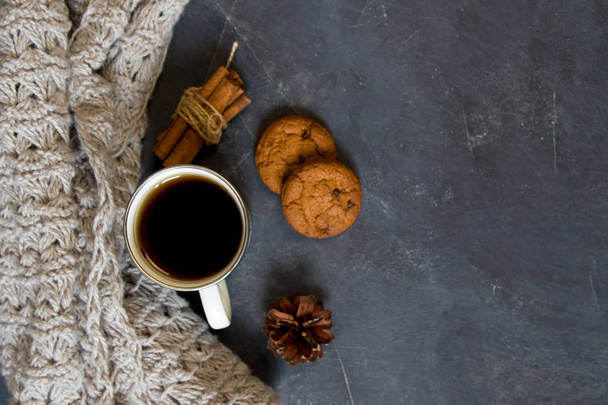 Σύνθεση του χειμώνα. Φλιτζάνι καφέ, μπισκότο, φώτα σε σκούρο φόντο. Επίπεδη θέσει - Φωτογραφία, εικόνα