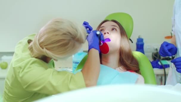 Стоматолог с помощью лампы для полимеризации стоматологических материалов
 - Кадры, видео