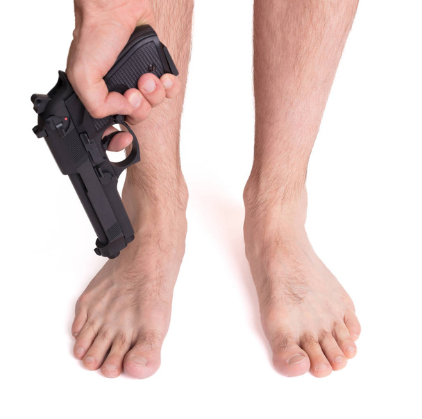 Concept - Man shooting himself in the foot - 写真・画像