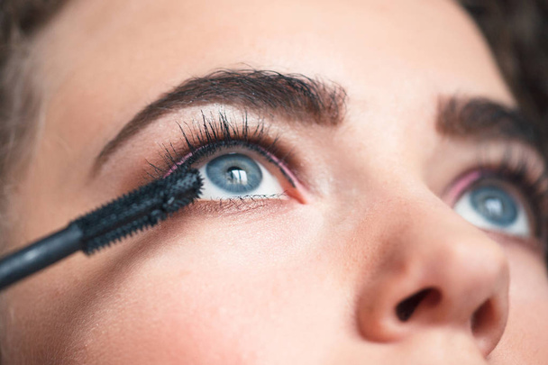 Zbliżenie wizażystka stosujące makijaż smokey eyes. Pojęcie piękna i makijaż - Zdjęcie, obraz