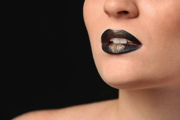 Mladá žena s extravagantní make-upu v černé a zlaté tóny, closeup - Fotografie, Obrázek