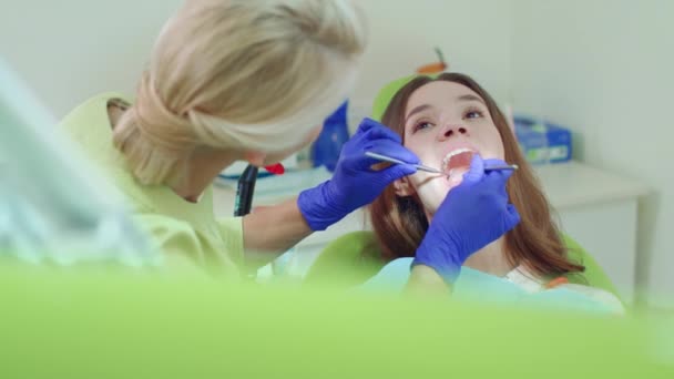 Technik dentystyczny, badając pacjenta zęby z narzędzi stomatologicznych - Materiał filmowy, wideo