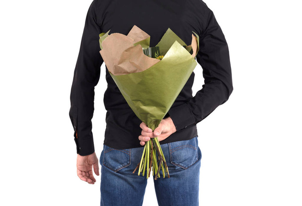 Ο άνθρωπος κρύβει λουλούδια πίσω από την πλάτη του - απομονωμένος - Φωτογραφία, εικόνα