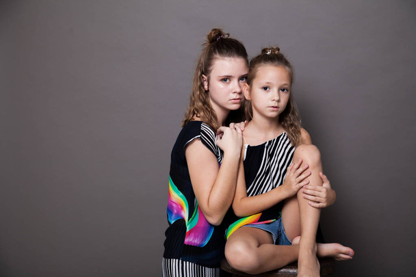 két divatos lányok nővérek a gyönyörű ruhákat portré - Fotó, kép