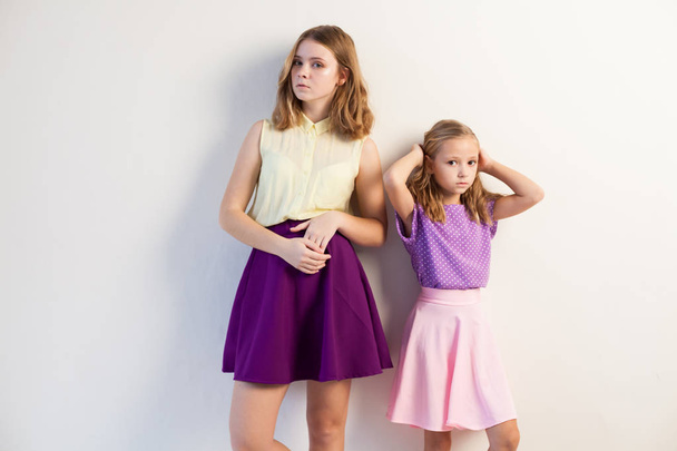 két divatos lányok nővérek a gyönyörű ruhákat portré - Fotó, kép