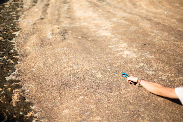 Giovane arrampicatore che mette il moschettone con la mano per assicurarsi sulla roccia
  - Foto, immagini