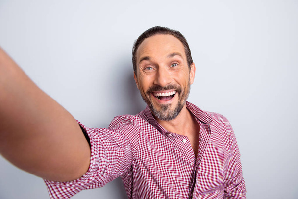 Good-wearing cheerful man in casual wear take selfie on smartpho - 写真・画像