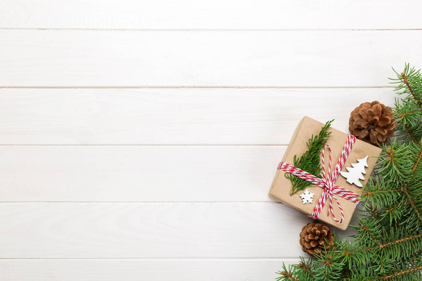 De gift van Kerstmis achtergrond Kerstmis met spar takken en dennenappels op houten witte achtergrond met kopie ruimte plat lag, top uitzicht. - Foto, afbeelding