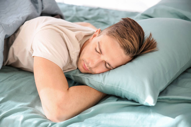 Handsome man sleeping in bed at home - Photo, image
