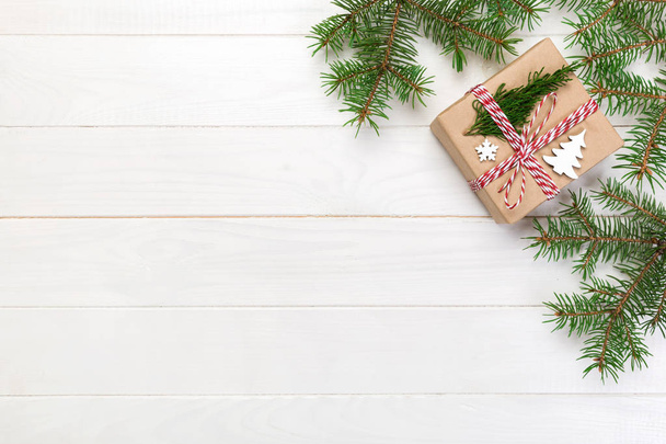 コピーと木製の白い背景の上のモミの枝で背景クリスマス ギフト フラット レイアウトをスペース、トップ ビュー. - 写真・画像