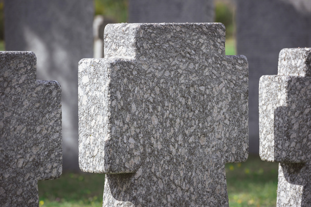 vista de cerca de las cruces de piedra conmemorativas colocadas en fila en el cementerio
 - Foto, Imagen