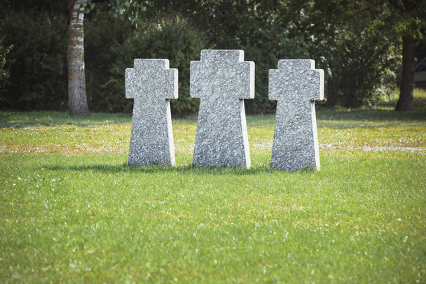 Gedenkstein-Kreuze reihenweise auf Gras auf Friedhof platziert - Foto, Bild